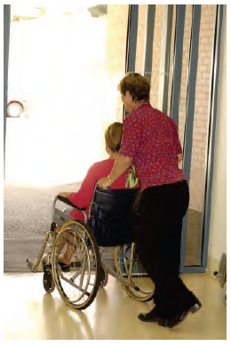 Photo of a health care professional pushing a patient in a wheelchair