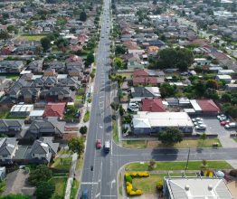 Aerial photo of a main road and the surrounding buildings and rooftops in a Melbourne suburb