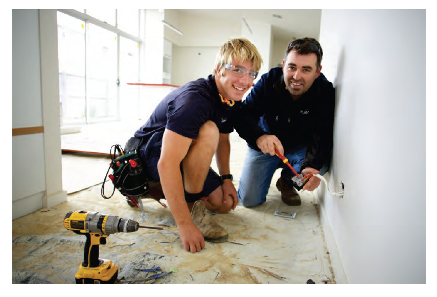 Photo shows an electrician apprentice at work with employer. Photo courtesy of the Victorian Registration and Qualifications Authority.