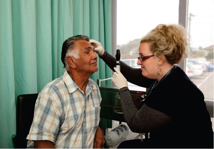 Image of a man sitting with a doctor at Gippsland Community Health Service. Photograph courtesy of Tobias Titz.