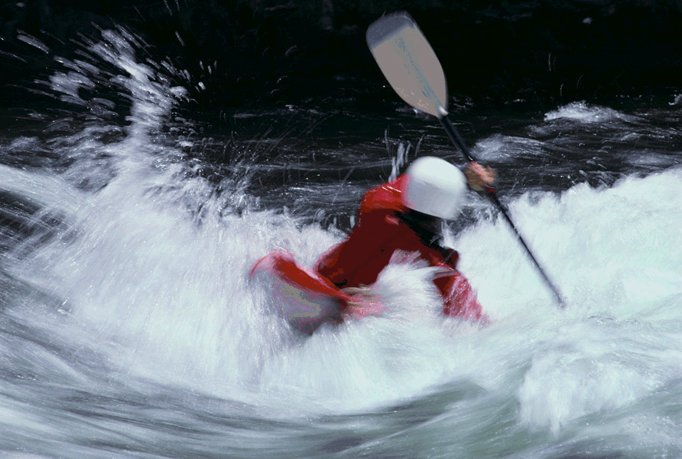 Image of a person kayaking through rapids.