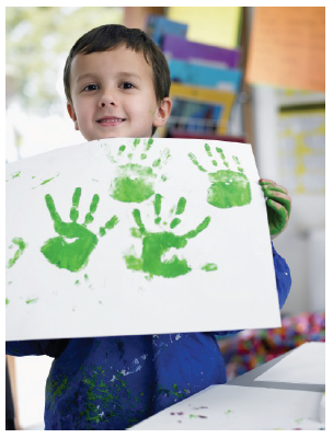 Image of a young boy holding up a finger painting. Photograph courtesy of bikeriderlondon/ Shutterstock.com