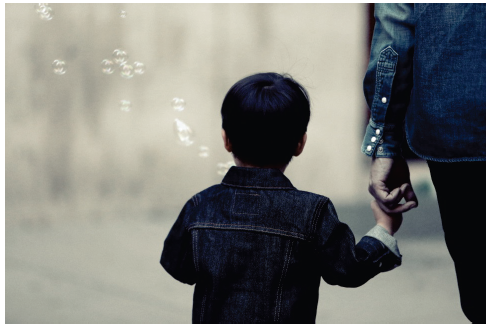 Image of a small child holding an adults hand. Photograph courtesy of Leeroy/stocksnap.io