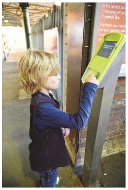 Image is of a young boy using a myki card reader. Photograph courtesy of Public Transport Victoria