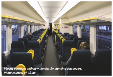 Photo showing the inside of a VLocity train carriage with handles fitted for standing passengers