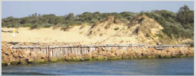 Lakes Entrance training wall, showing the rock protection failing.