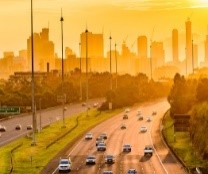 Sunset view over traffic on Melbourne's Eastern Freeway, looking towards CBD skyscrapers.