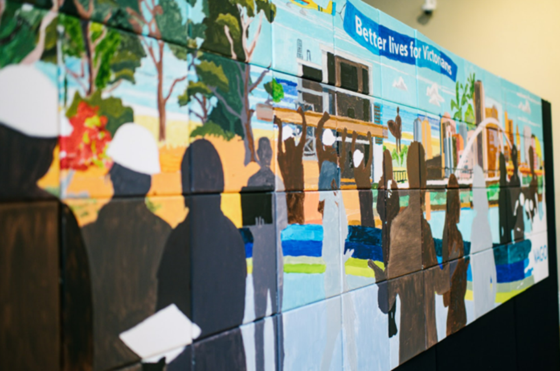 Photo of mural titled 'Better lives for Victorians' that shows workers in silhouette against a background of scenes from places in Victoria.