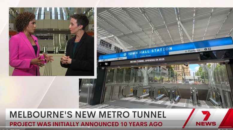 Screenshot of a 7 News television broadcast. The caption says ‘Melbourne’s new metro tunnel. Project was initially announced 10 years ago’. On the top left is a reporter speaking with the Minister for Transport. On the right is a photo of the escalators at Town Hall Station. 