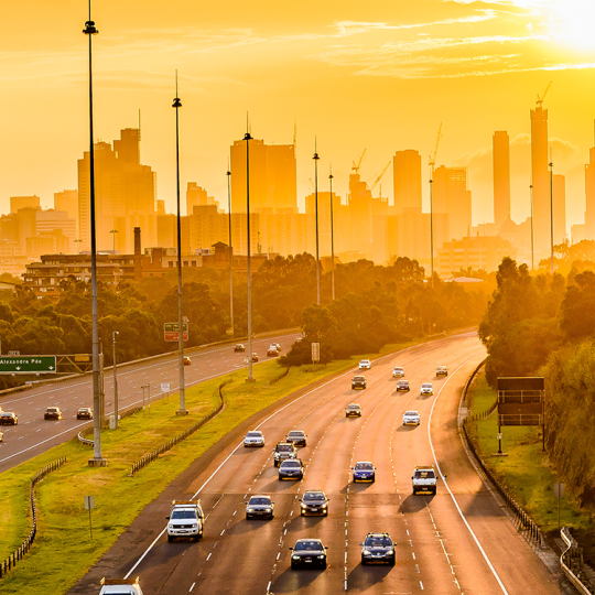 Sunset view over traffic on Melbourne's Eastern Freeway, looking towards CBD skyscrapers