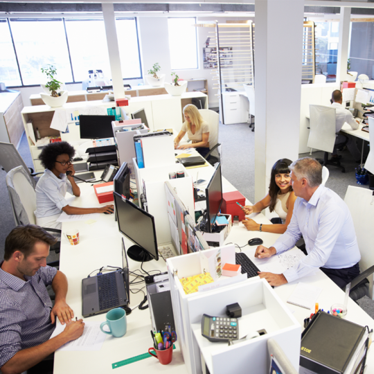 People working in a bright, busy open-plan office.