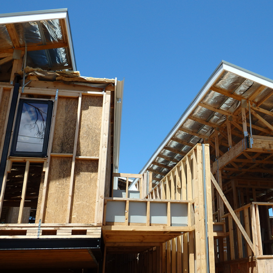 Domestic home in the building stage with wooden frame and bare roof.