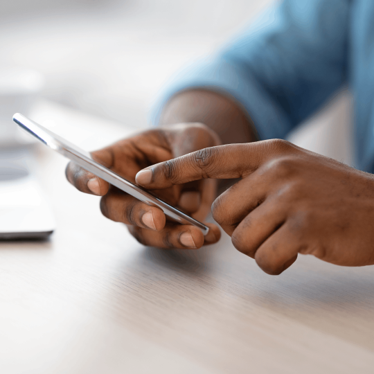 Hands browsing a mobile phone