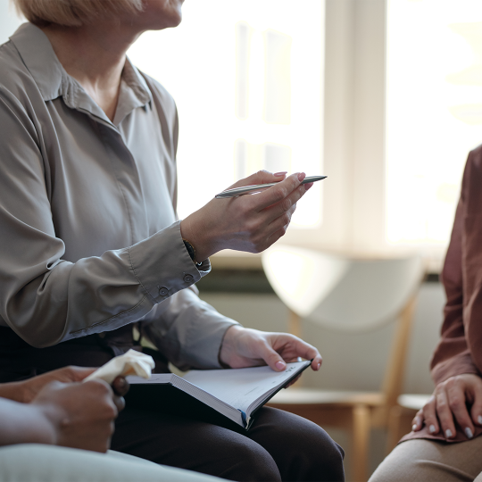 Close-up of a person gesturing with their hands during a meeting.