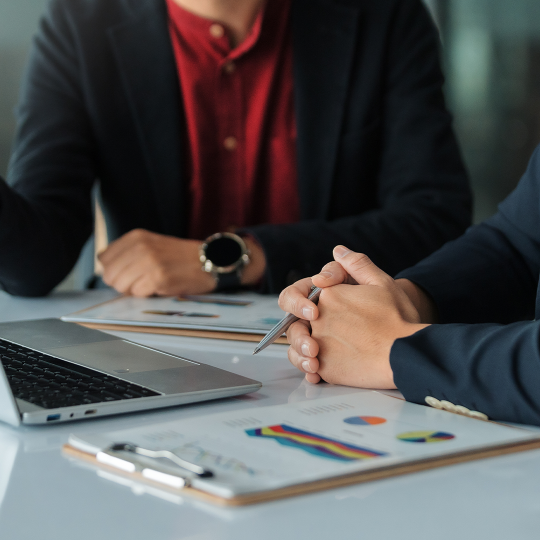 People looking at a laptop with clipboards