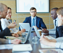 People sitting around a board room table. Photo courtesy of Pressmaster/Shutterstock.com