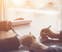 Two business men signing a contract. Photo courtesy of Have a nice day Photo/Shutterstock.com
