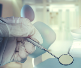 A dentist holding dental instruments. Photo courtesy of Vladislav Max/Shutterstock.com 