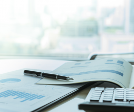Annual report documents and calculator on a desk.