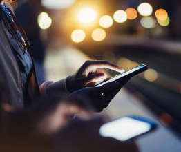 Woman using smartphone at train station.