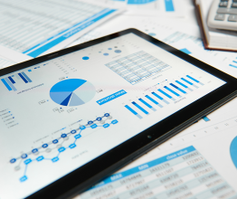 iPad screen and printouts showing accounts graphs and tables. 