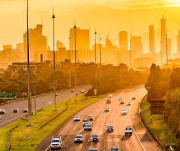 Sunset view over traffic on Melbourne's Eastern Freeway, looking towards CBD skyscrapers