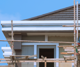 Scaffolding around the top floor of a house under construction.