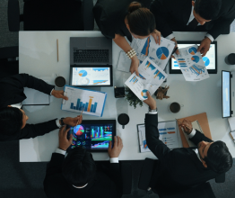 Overhead photo of business people looking at charts and data to make a decision.