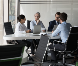 Four office workers talking around a table.