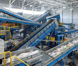 Conveyor belts carrying recycled materials through an indoor recycling facility.