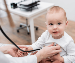 A baby with a stethoscope to its chest