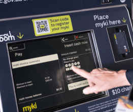 Hand pressing a button on a myki top-up machine