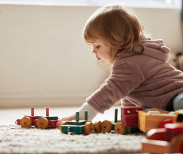 Toddler playing with toys in a living room