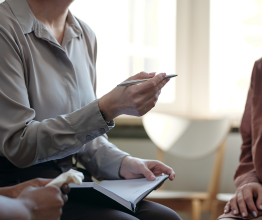 Close-up of a person gesturing with their hands during a meeting.