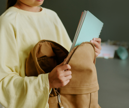 A child taking a notebook out of a backpack.